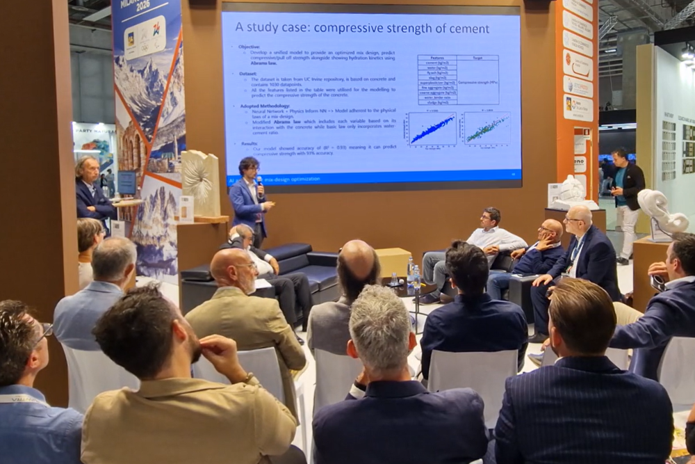 Persona che presenta un progetto di AI applicato al recupero dei materiali lapidei davanti ad una platea di persone sedute