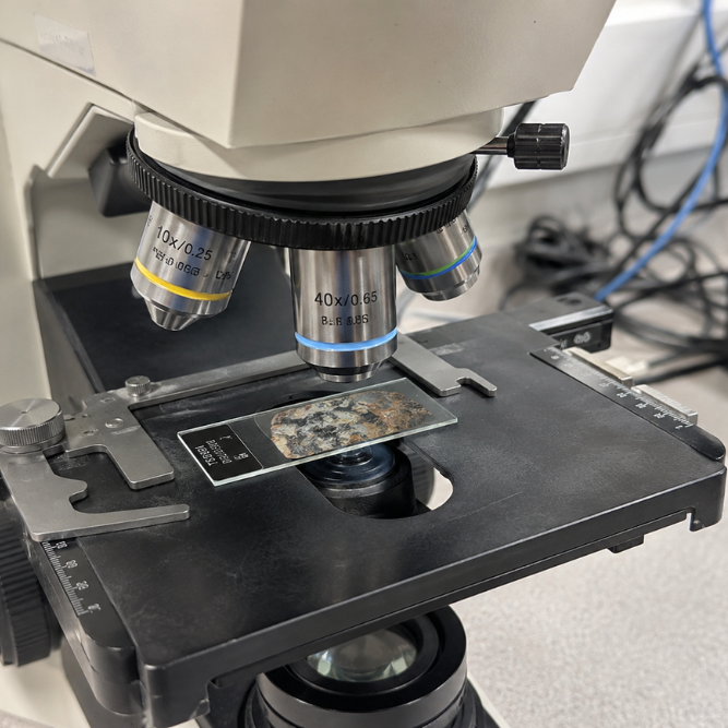 Microscopio che analizza la composizione di una pietra